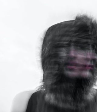 Creepy blurred photo of a person's face and a furry hood