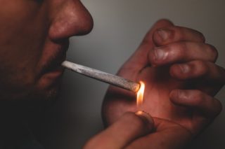 man lighting cigarette