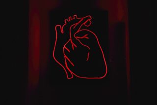 red drawing of heart on black background