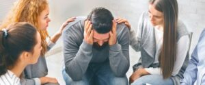 Depressed man with drug problem sitting in rehab center