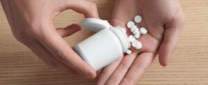 Man pouring pills from bottle