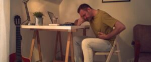 Man with stomach and headache while working at home