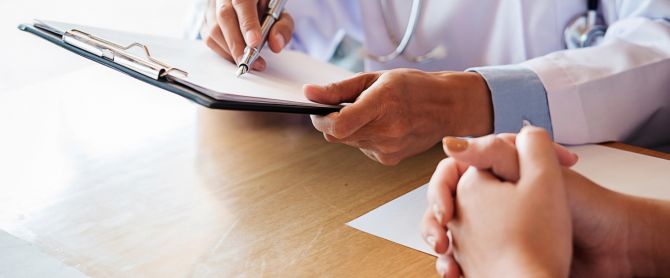 Patient listening intently to a male doctor explaining patient symptoms