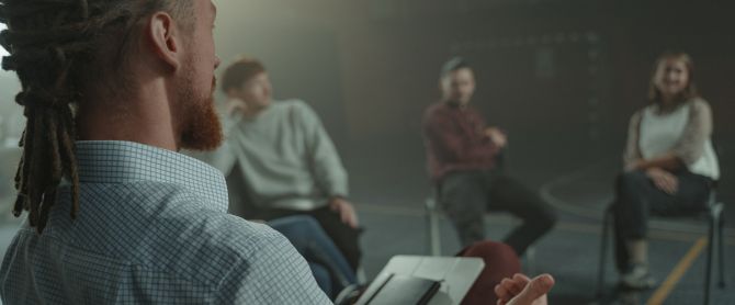 A group of adults engaged in a casual discussion indoors