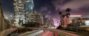 Los Angeles skyline with illuminated highways and towering buildings.