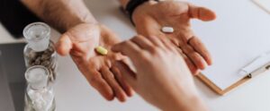 hands exchanging pills in a clinical environment