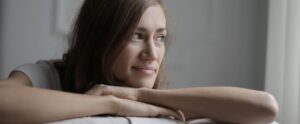 A young woman rests on a sofa inside
