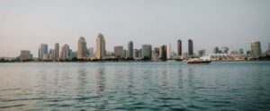 San Diego skyline reflecting on the bay with a yacht cruising by