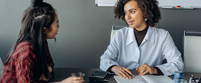 Two women in an office setting discussing insurance