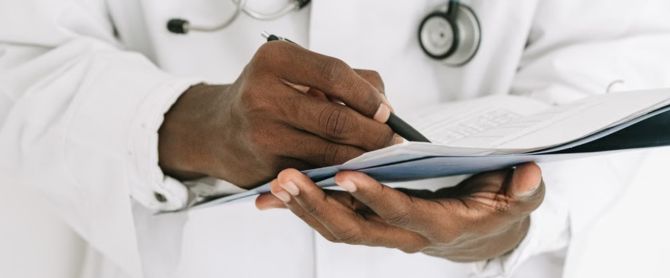 Professional doctor writing on a clipboard